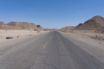 Asphalt road along sand dunes in desert