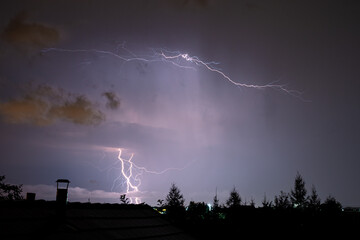 Several lightning bolts cut through the night sky over Transylvania, Romania during a thundery night