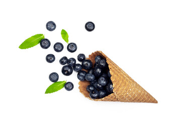 Fresh ripe blueberry and mint leaves in waffle cone. Ice cream cone with ripe sweet berries on white background with copy space. Summer creative concept, flat lay, Top view.