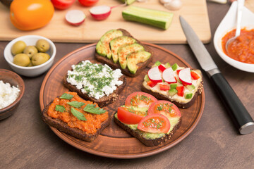 Assortment vegan, vegetarian sandwiches. Healthy homemade toasts with different vegetables and greens on plate close up	
