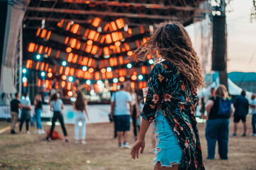 Beautiful woman drinking beer and having fun on a festival with her friends
