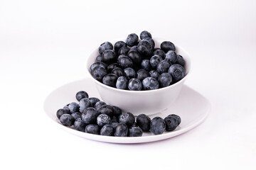 Blueberry in white bowl and plate on white background.