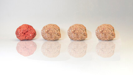 VIEW OF FOUR BALLS MADE OF PORK AND BREADCRUMBS ON A WHITE BACKGROUND