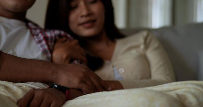 Selective focus, Close up scene, Male hands place on hand of his girlfriend while watching romantic movie on TV.