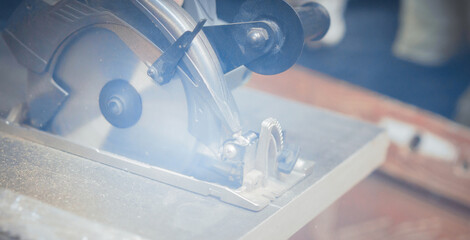  carpenter cuts a wooden panel with a power tool