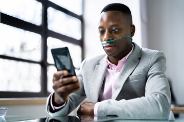 African Man Using Phone With Nasal Oxygen Cannula