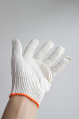 A hand in a white glove on a white background. Personal protective equipment. A man's hand in a white glove on a white background close-up. Hand in glove isolated. 