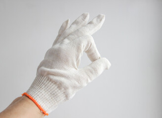 A hand in a white glove on a white background shows the 