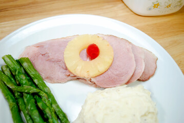 Close Up of a Delicious Ham Dinner	with Mashed Potatoes and Fresh Steamed Asparagus