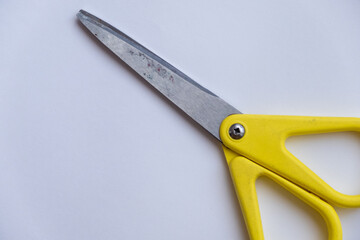 scissors with yellow grip on white background