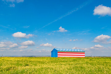 Sunny view of a American flag decorated wooden farm house