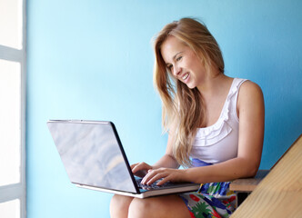 Networking keeps her in the loop. Cropped shot of a young teen using a laptop in her bedroom.