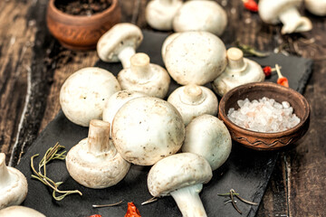 Fresh champignons with spices and herbs. Raw ingredient for cooking vegan food
