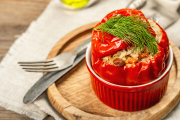 Homemade meat and rice stuffed bell peppers. Olive oil, sauce, cutlery on vintage wooden background