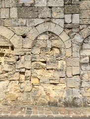 Saint Emilion, Bordeaux, France. Wall. Fragment of stone medieval wall decorated with arches. Limestone stone wall