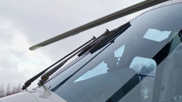 close up view of windshield wipers of civil or military aviation helicopter. Business helicopter, blue transparent windshield.