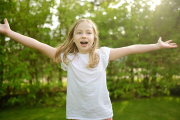 Cute young girl having fun outdoors on summer evening. Child exploring nature. Summer activities for kids.