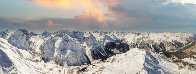 sunset over a mountain valley in the snow  - obrazy, fototapety, plakaty
