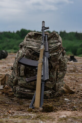 Army backpack with AK rifle isolated on nature background
