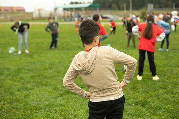 Schoolboy does gymnastics in park. Sports activity for children. Health Day in Russia.