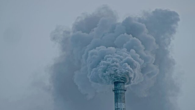 This smoke coming from the chimney in a factory. Harmful emissions into the atmosphere, from the pipe. Serious damage the environment. Plant stack Coaling station. Close up shot. Dark sad view.