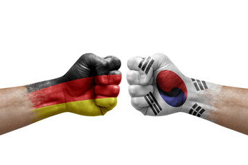 Two hands punch to each others on white background. Country flags painted fists, conflict crisis concept between germany and south korea