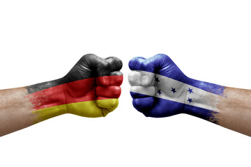 Two hands punch to each others on white background. Country flags painted fists, conflict crisis concept between germany and honduras