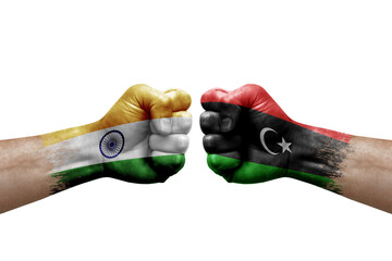 Two hands punch to each others on white background. Country flags painted fists, conflict crisis concept between india and libya