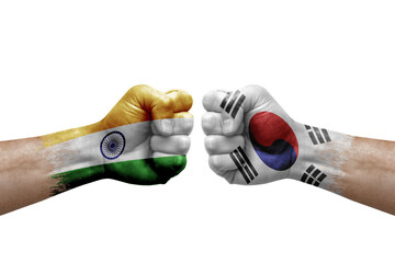 Two hands punch to each others on white background. Country flags painted fists, conflict crisis concept between india and south korea
