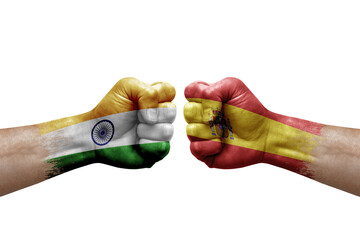 Two hands punch to each others on white background. Country flags painted fists, conflict crisis concept between india and spain