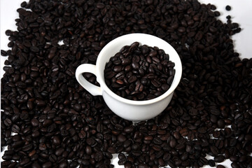 white cup with roasted coffee beans isolated with copy space