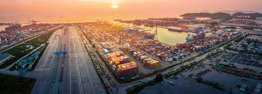 The International cargo container depot at sunset , multiple supply chain truck train and cargo ship working service shipping and transportation concept logistic and transport.