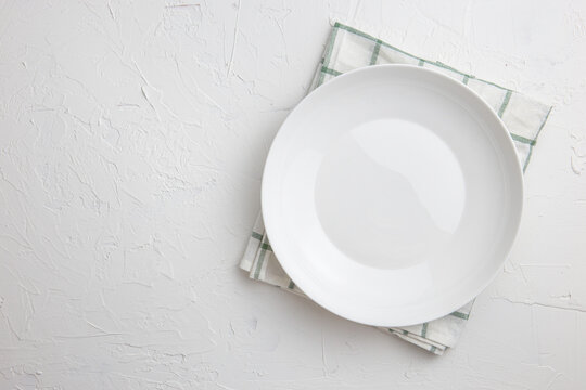 .Kitchen table with empty plates and towels Stone cooking backdrop Top view with flat copy area