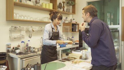 An angry customer shouting and blaming a woman barista who made a mistake. Collecting an order at the counter in coffee shop cafe cashier. Business service. People lifestyle.