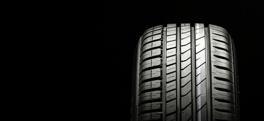 beautiful new summer tire on a black background. summer protector against aquaplaning and fuel economy copy space,