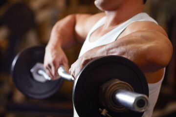Workout with weights. A young man lifting a dumbbell at the gym.