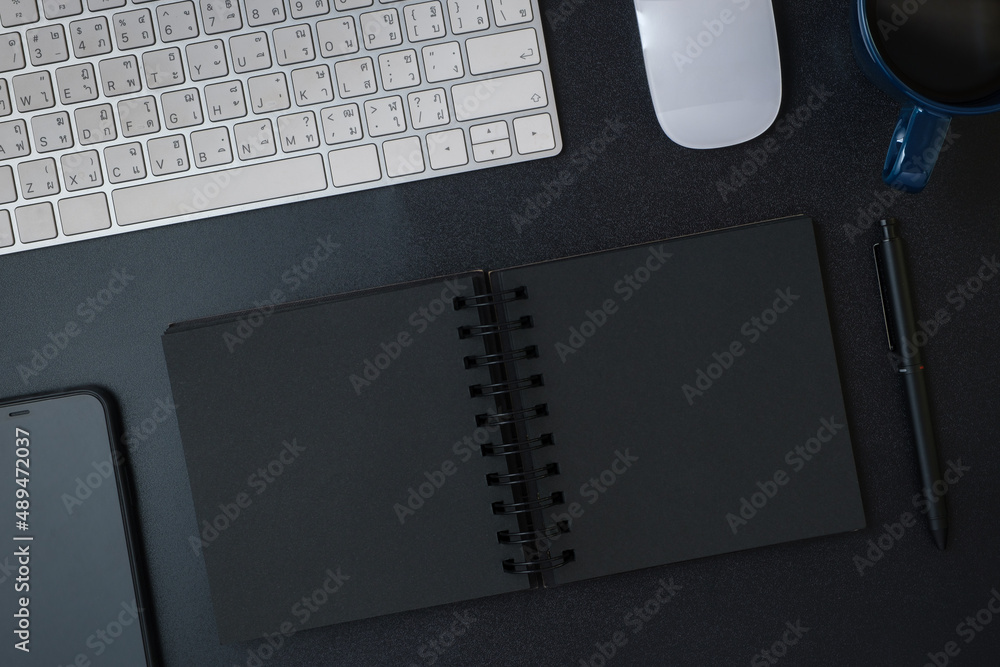 Poster top view working desk with keyboard headphone and open notebook on black table background