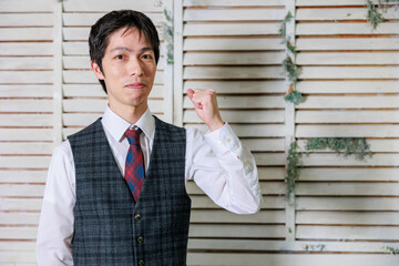 ベストを着た日本人男性が微笑む