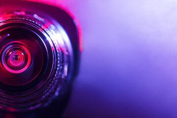 Fototapeta na wymiar Camera lens with purple and pink backlight. Optics