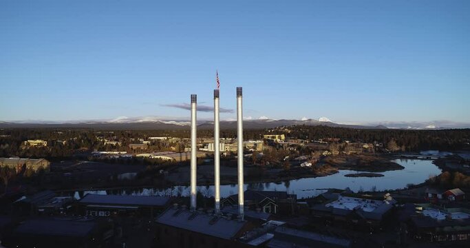 Aerial drone video of the Old Mill District smokestacks on the Deschutes River in Bend, Oregon.
