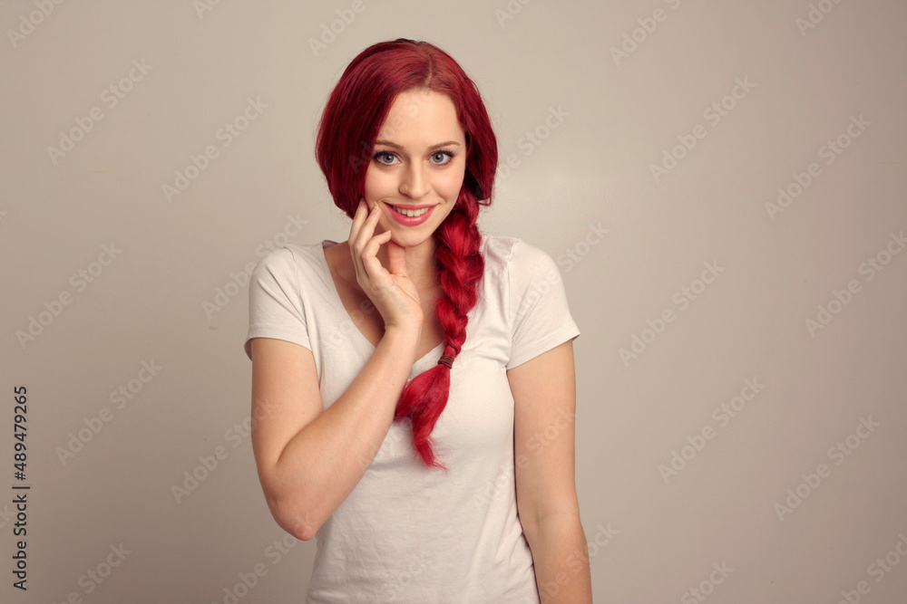 Sticker close up portrait of pretty female model with red hair in a braid, expressing emotion over the top facial expression on a studio background.