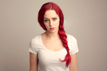 close up portrait of pretty female model with red hair in a braid, expressing emotion over the top...