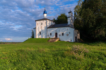 Fototapeta na wymiar Saint Nicholas Church in Gorodishche (Nikolskaya church) on Truvorov Gorodishche on a sunny summer day with clouds. Stary Izborsk, Pskov region, Russia