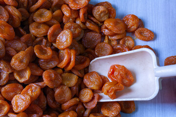 pitted dried apricots in a blue cardboard box with a scoop