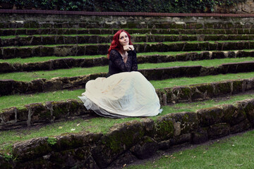 Full length portrait of red-haired woman wearing a  beautiful gothic gown costume, walking around ...