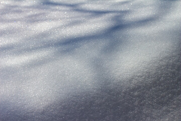 Close-up abstract texture background of heavy snow on the end of a home rooftop, with faint tree shadows and copy space