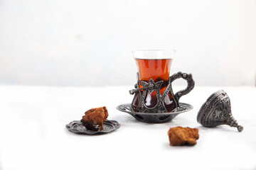 Chaga tea in a Turkish glass on a light background. Healthy food concept. Copy spaes.
