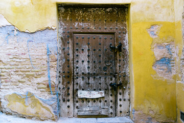old door in the old wall in toledo spain, with a yellow wall.