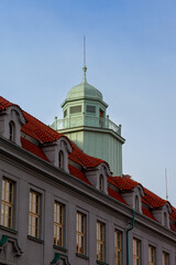 Fototapeta premium Belvedere rotunda above the red roofs. A water green rotunda dominates the red roofs of a baroque building. The sky is cloudless blue.