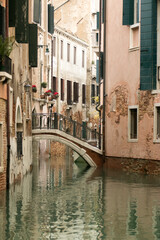 Fototapeta na wymiar Ancient and beautiful canals of Venice with pale colors and old bridges